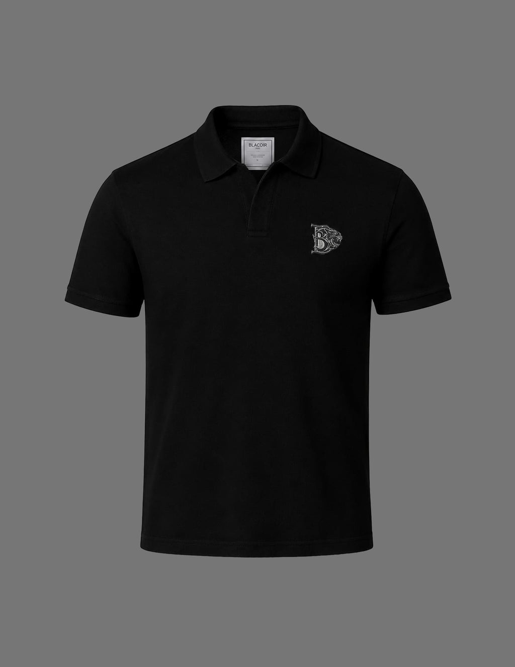 Premium black BLACOIR Crest V-Collar Tee featuring a tonal silver crest emblem on the chest, structured V-collar polo neckline, short sleeves, and minimalist luxury design on a neutral grey background.