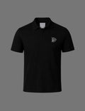 Premium black BLACOIR Crest V-Collar Tee featuring a tonal silver crest emblem on the chest, structured V-collar polo neckline, short sleeves, and minimalist luxury design on a neutral grey background.