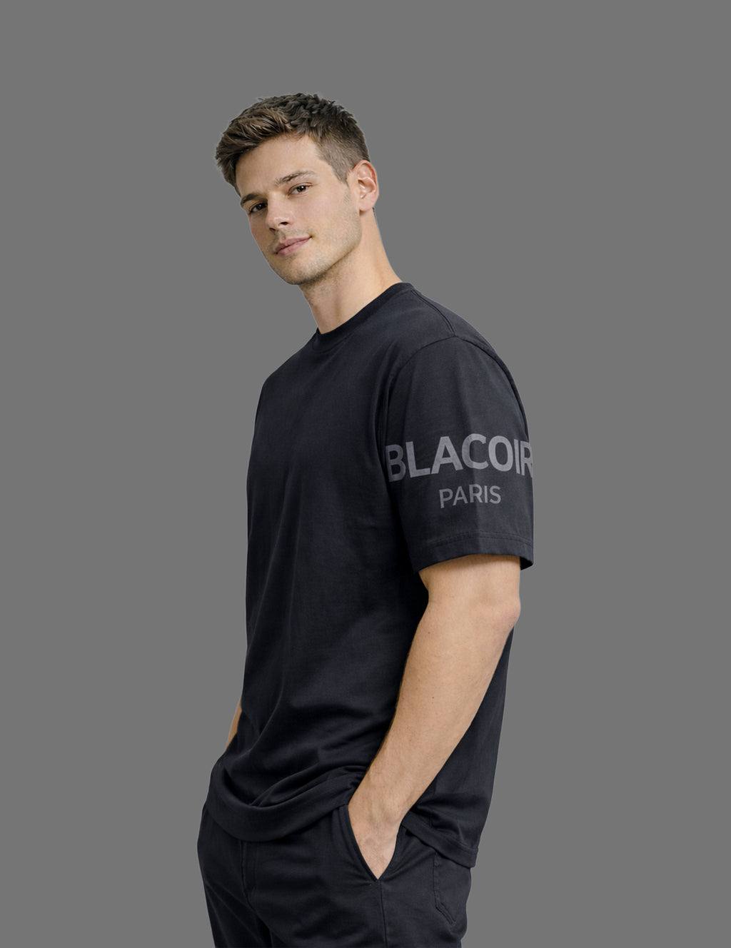 Man wearing a black t-shirt with 'Blacoor Paris' logo on a gray background