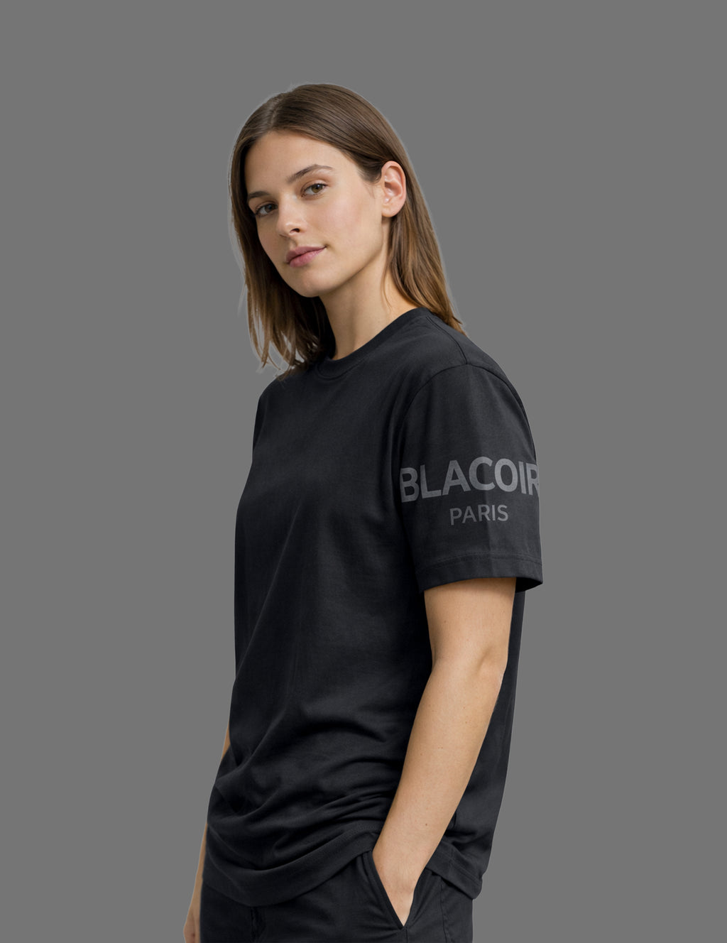 Woman wearing a black t-shirt with 'Blaccon' logo on a gray background